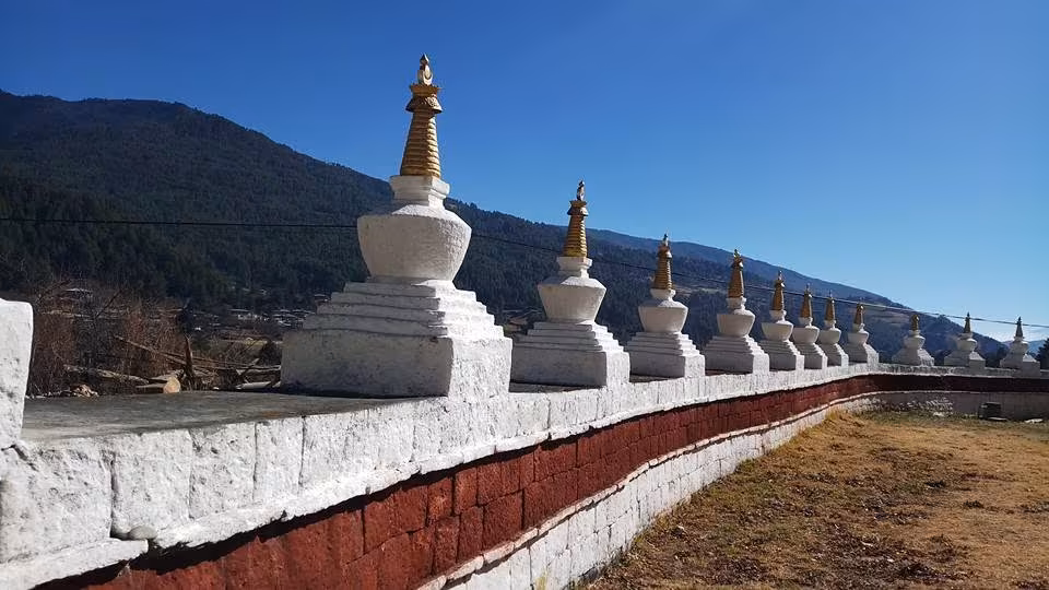 A line of whitewashed chortens along the wall of Jakar Dzong