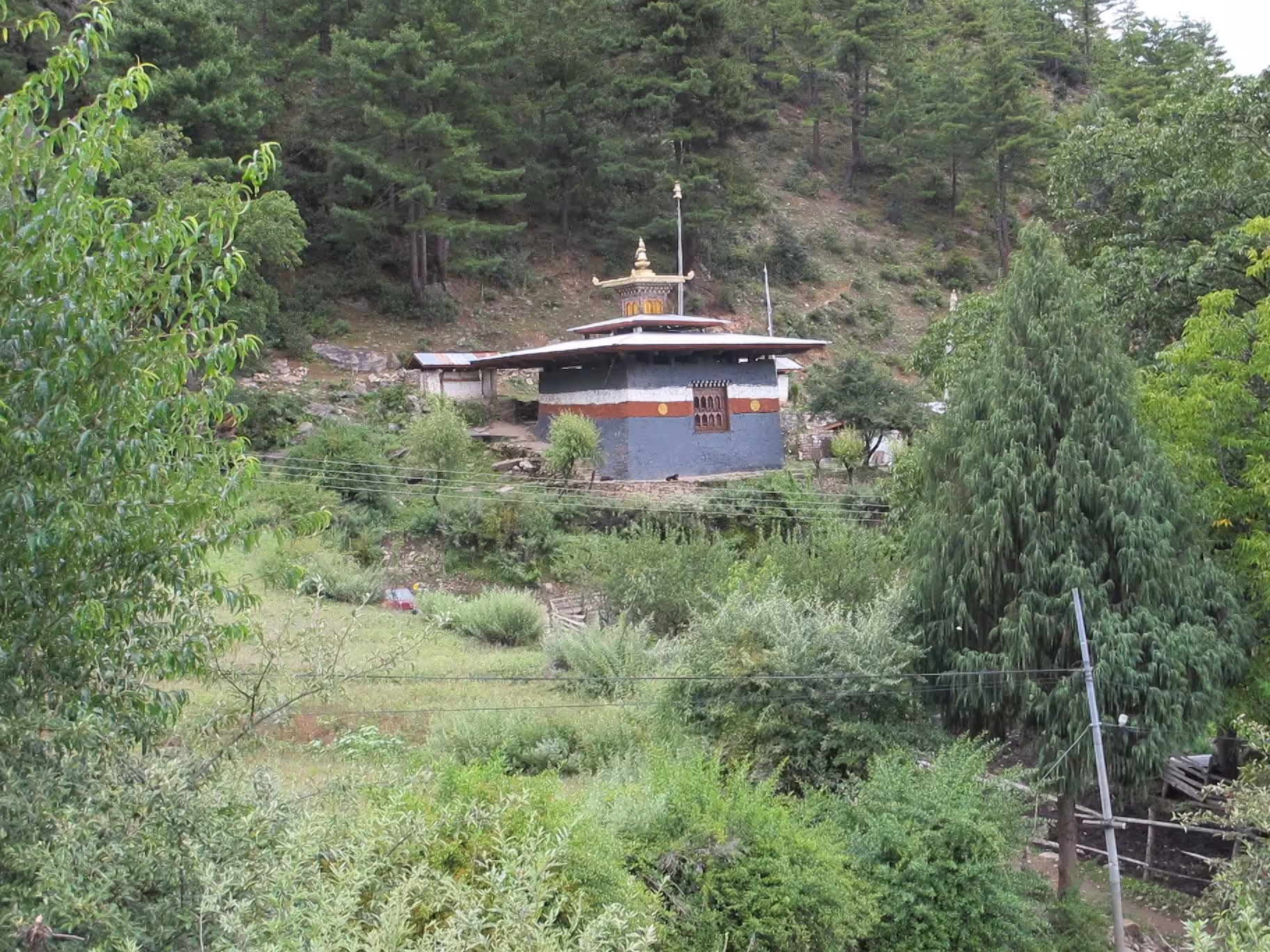 Lhakhang Nagpo seen across scrub and pasture