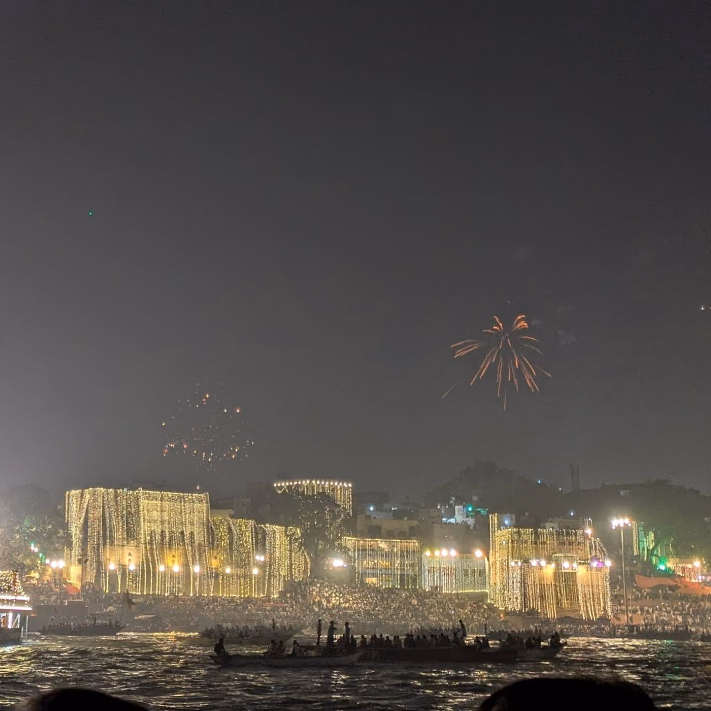 Illuminated ghats and fireworks seen from a boat on the Ganga
