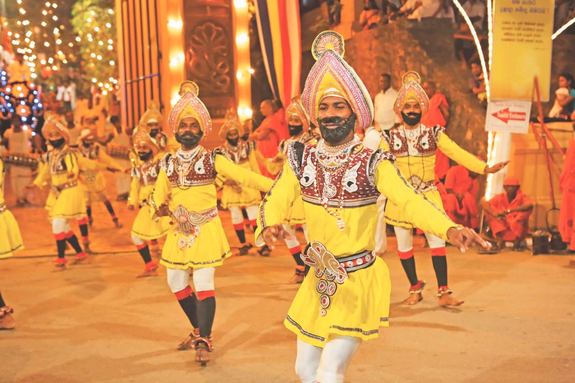 Dancers in yellow costumes in the Duruthu Perahera procession