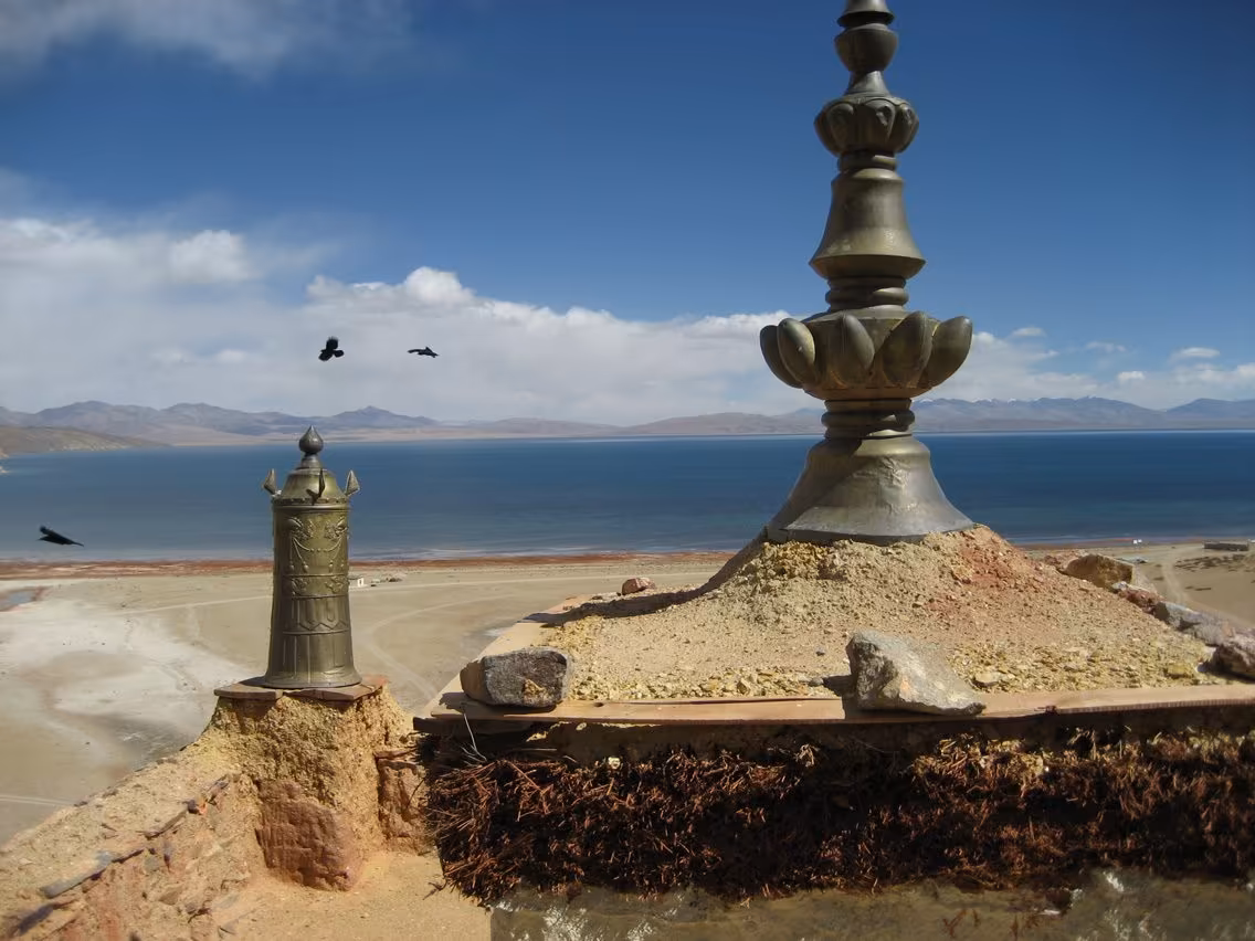 Brass finials on the roof of Chiu Gompa above the blue expanse of Lake Manasarovar
